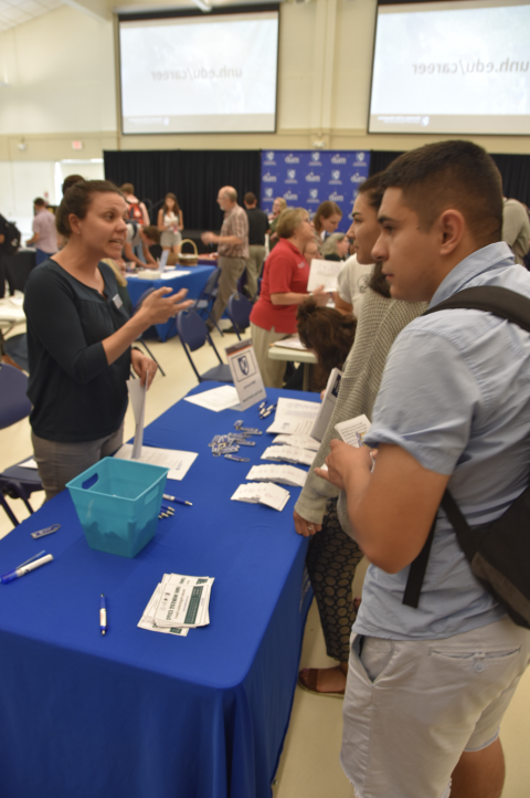 Image of UNH students talking to a UNH department about Work Study at the Part-Time and Work Study Job Fair