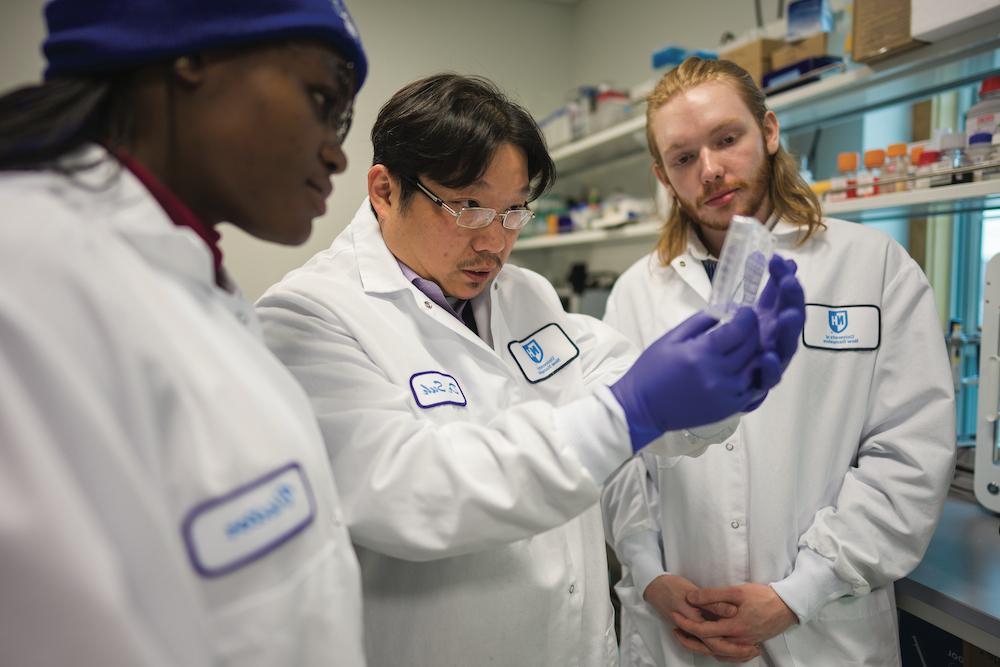 UNH researcher Won Hyuk Suh in lab with two students